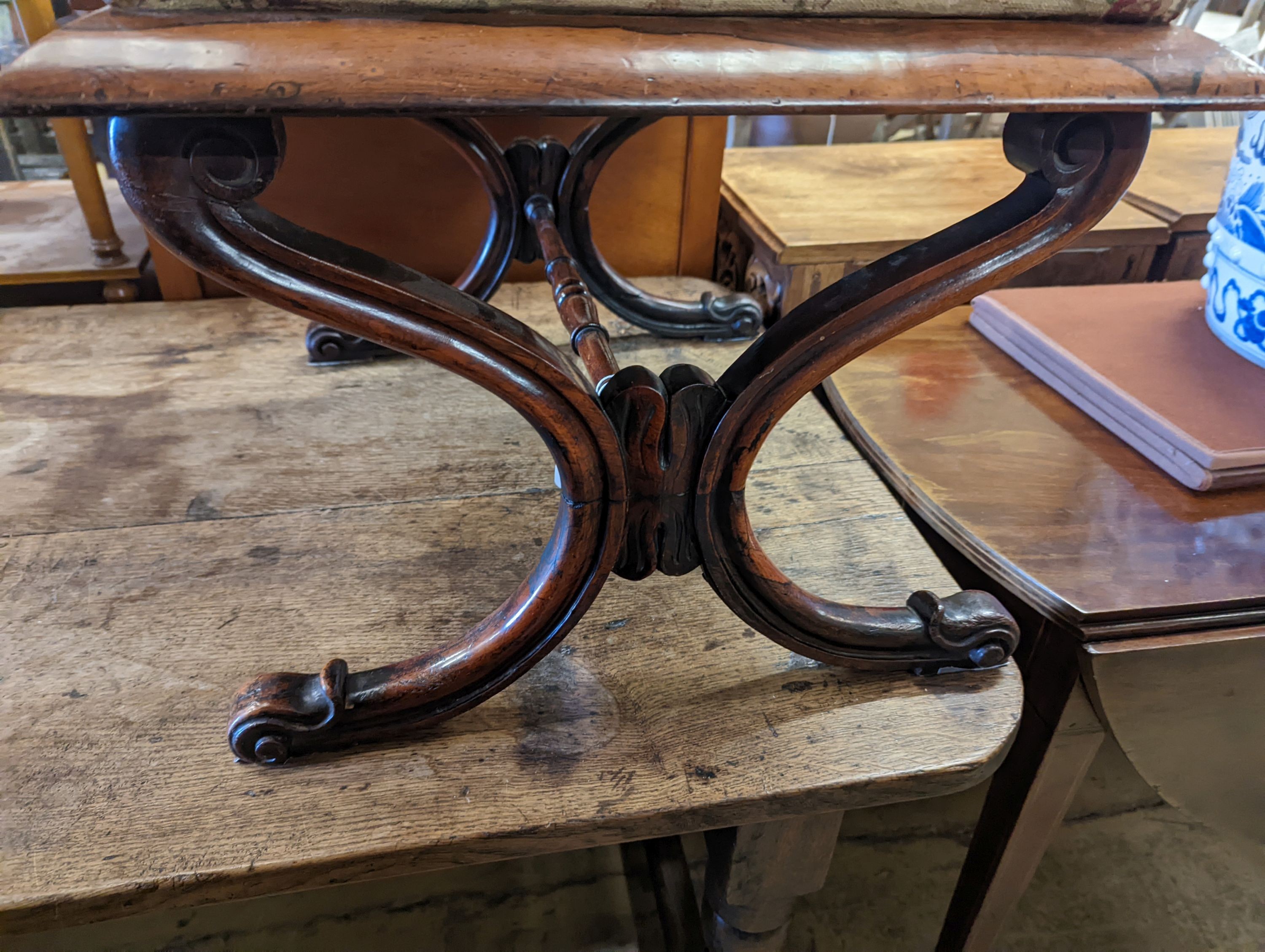 An early Victorian rectangular rosewood X frame dressing stool, length 59cm, depth 48cm, height 42cm